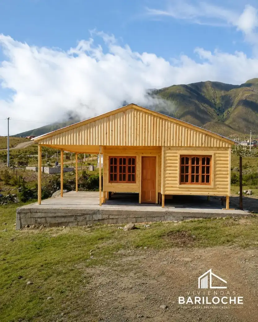 Casa de madera con porche frente a los cerros